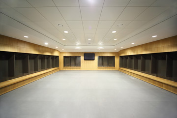 large clean locker room. gray floor and ceiling, big televisor