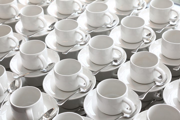 many rows of pure white cup and saucer with teaspoon
