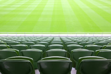 Fotobehang Stadion Rijen opgevouwen, groene, plastic stoelen in een heel groot, leeg stadion