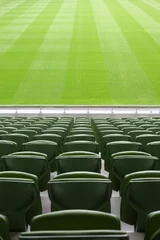 Foto op Plexiglas Stadion Rijen opgevouwen, groene, plastic stoelen in een heel groot, leeg stadion