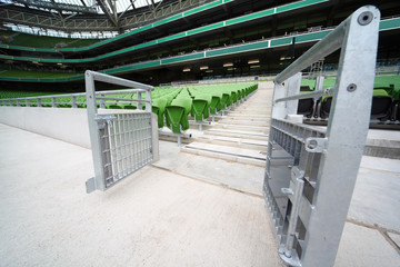 Fototapeta premium Rows of folded, green, plastic seats in very big, empty stadium,