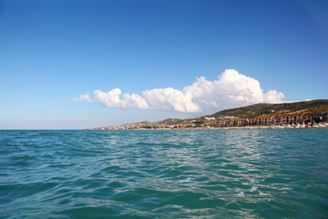 Fototapeta premium blue water of sea, far away beach, mountains and building