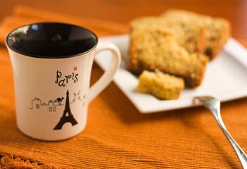 White cup and cake on a plate.