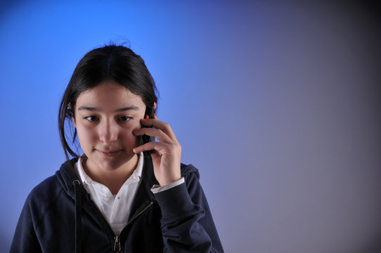 Teen girl speaking on cell phone with big copy space.
