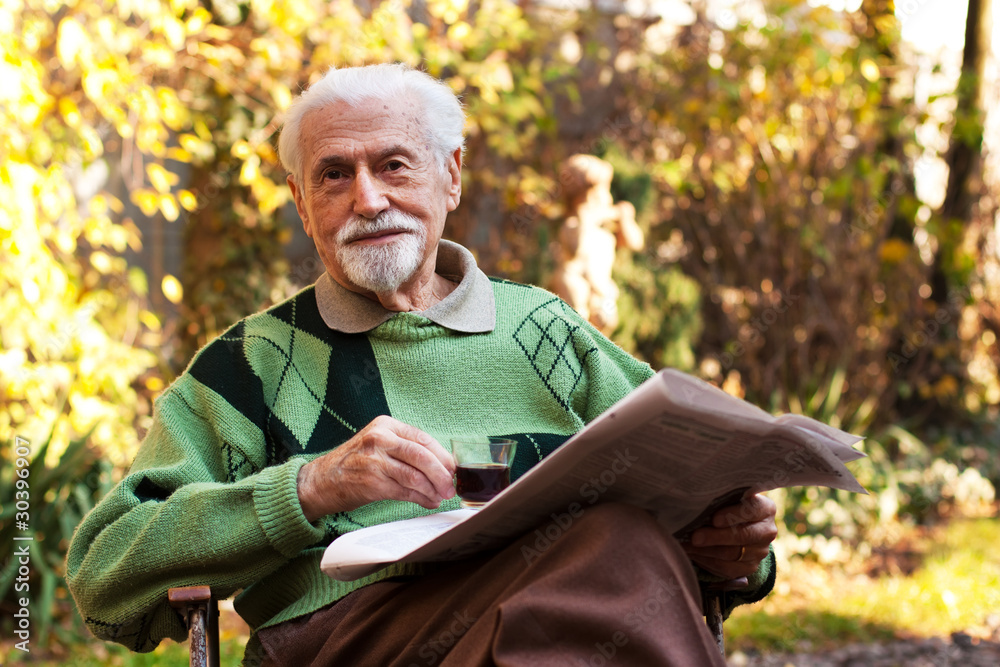 Wall mural Elderly man reading the paper