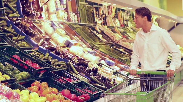 Mann im Supermarkt kauft Gem&uuml;se