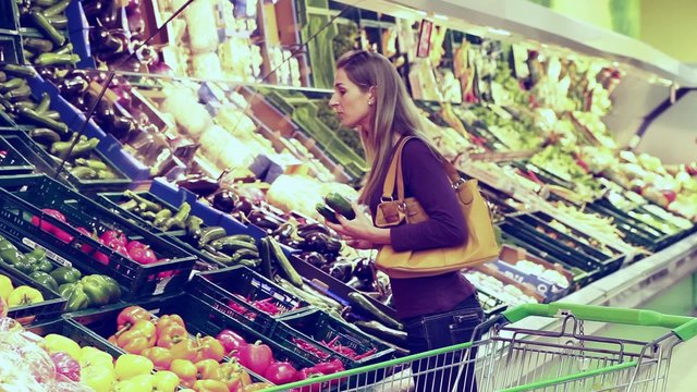 Frau im Supermarkt kauft Gem&uuml;se