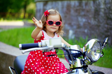 Fototapeta premium Girl in a red dress on a motorcycle