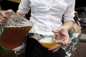 Beer Waitress Bar Maid pouring draught beer from a pitcher