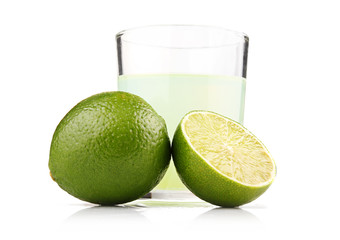 Glass of lime juice and lime fruits with slices isolated