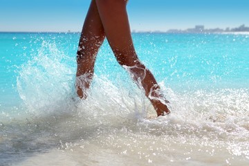 Woman legs walking splashing beach aqua water