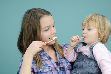 teenager and baby girl studying toothbrush movements