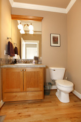 Fototapeta na wymiar Beige powder restroom with nice hardwood floor.