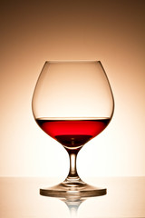 Glass of brandy over gold background