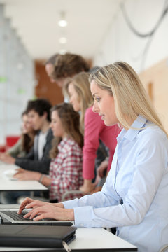 teacher working on laptop computer in classroom