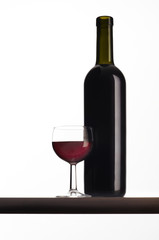 bicchiere di vino rosso con bottiglia su fondo bianco