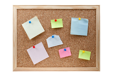 different sticky notes on a cork board isolated