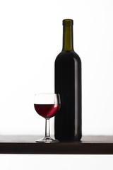 Bottiglia di vino rosso con bicchiere su fondo bianco