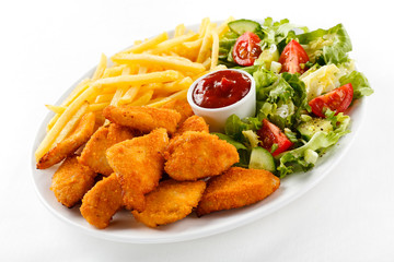 Fried chicken nuggets, French fries and vegetables