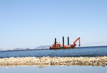 paisaje maritimo con barco excavadores