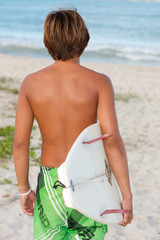 Surfer heading to the ocean in Hawaii