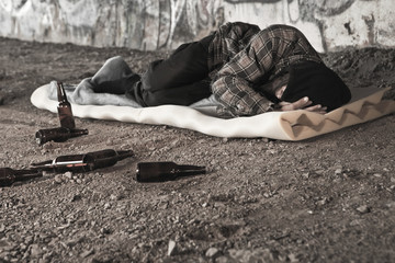 Homeless alcoholic sleeping outdoors