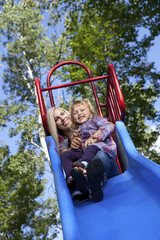 Mother and daughter on a slide in a park