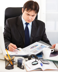 Thoughtful businessman and working with financial documents.