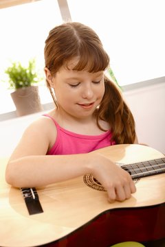 Small girl playing guitar