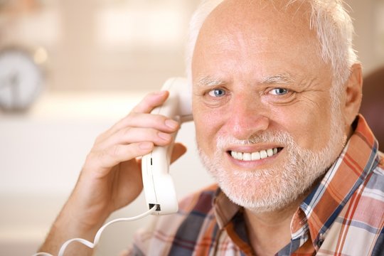 Portrait of smiling senior using landline phone
