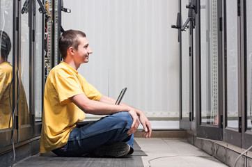 The engineer sits front equipment in datacenter - 30458580