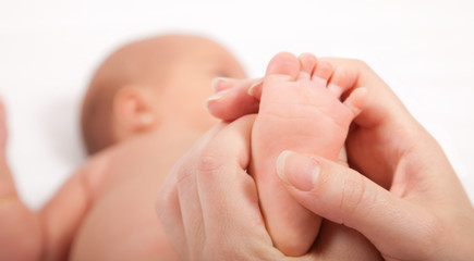 Fototapeta na wymiar Ręce matki małego dziecka masowania stóp