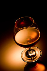 Glass of brandy over gold gradient background