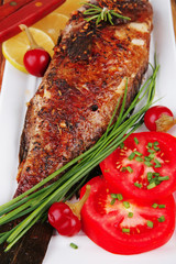 whole fried bass on plate over wood