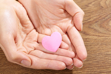 Obraz premium Woman holding pink heart in the hand