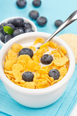 bowl of cornflakes with milk and blueberries