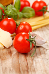 pasta, olive oil and tomatoes on the wood background