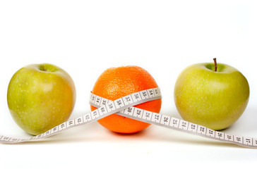 Two green apples and one orange with tape.