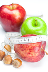 apple, nuts and measure tape isolated on white