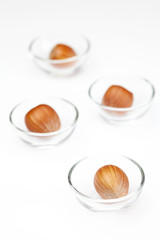 Nuts in miniature glass bowls isolated on white