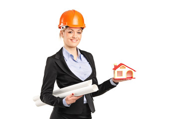 Smiling forewoman holding a model house and blueprints