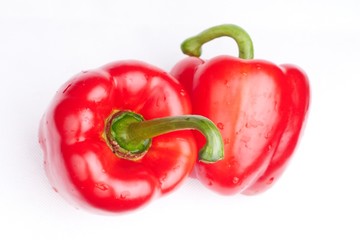 two red paprikas on white background