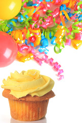 Birthday cupcake with balloons and ribbons.