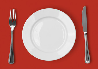 Knife, white plate and fork on red background