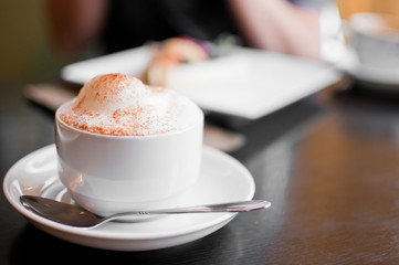 A cappuccino cup with milk foam and cinnamon