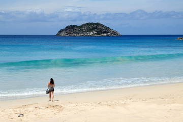 jeune femme sur plage de sable blanc aux Seychelles
