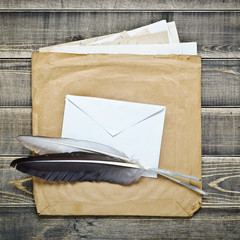 Vintage envelopes with paper and feathers