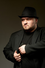 Man in black suite with gun.