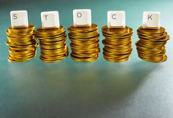 STOCK letter on gold coins stack