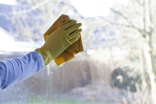 Mann beim Fenster putzen